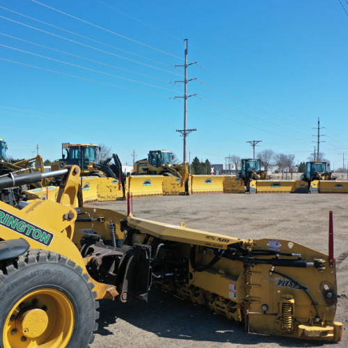 Multiple wheel loaders equipped with large snow pushers line up for rapid deployment in a commercial snow removal service by Carrington Lawn & Landscape in Middleton, Madison, and the greater Dane County area