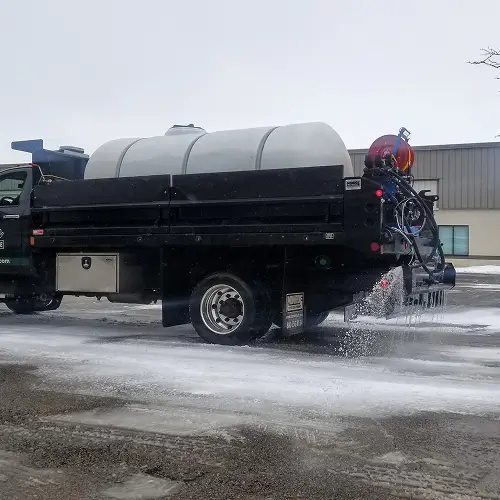 Carrington Lawn & Landscape truck spreading liquid brine during snow control operations for Salt Wise Certification in Middleton, WI