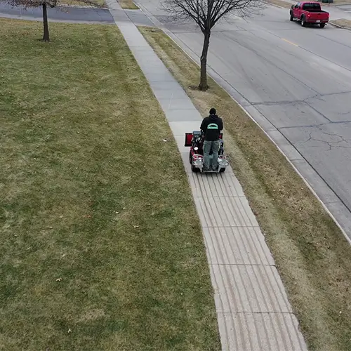 Carrington Lawn & Landscape team performing sidewalk deicing using Salt Wise Certification methods in Middleton, WI