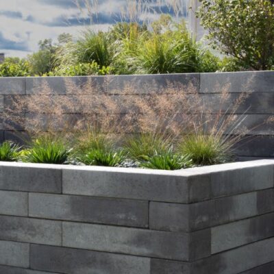 Gray concrete block retaining wall with tiered landscaping instaled by Carrington Lawn & Landscape hardscape design contractors in Middleton, WI