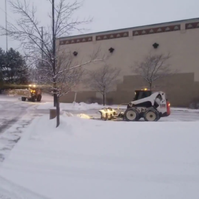 Snow removal machine clearing a brick pathway in winter for snow and ice management in Madison, WI