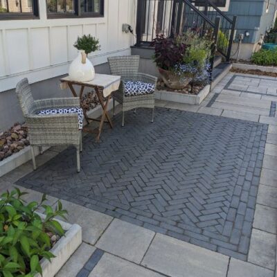 dark grey woven Paver Pattern acting as an accent rug design with larger gray paver tiles surrounding the border 