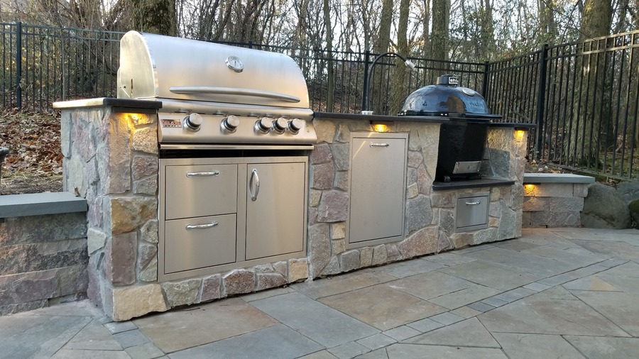 Luxury outdoor kitchen with custom stonework and lush landscaping