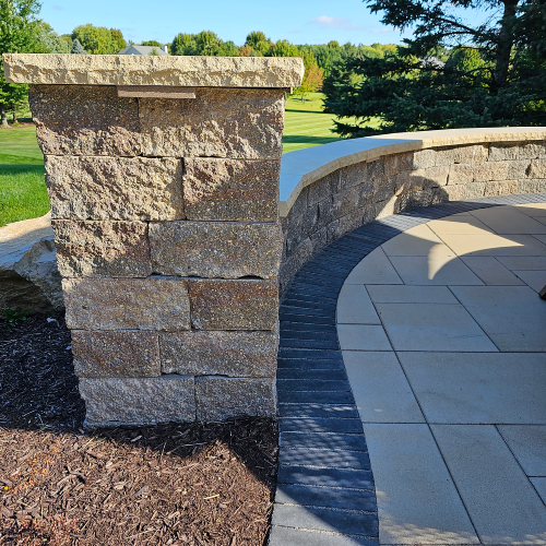 Closeup of curved stone wall feature on a multi level paver patio by Carrington Lawn & Landscape in Wisconsin