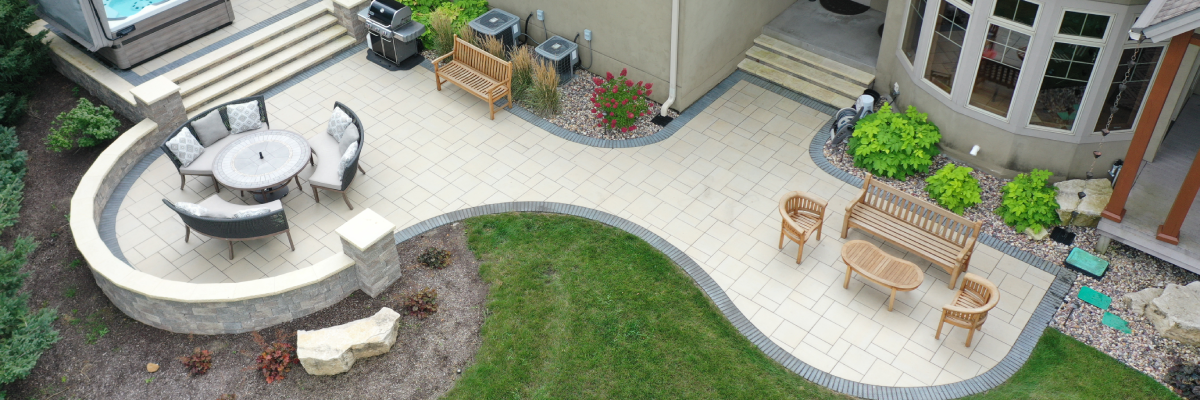 Aerial view of a custom multi level paver patio with outdoor seating, dining area, and landscaping in Wisconsin