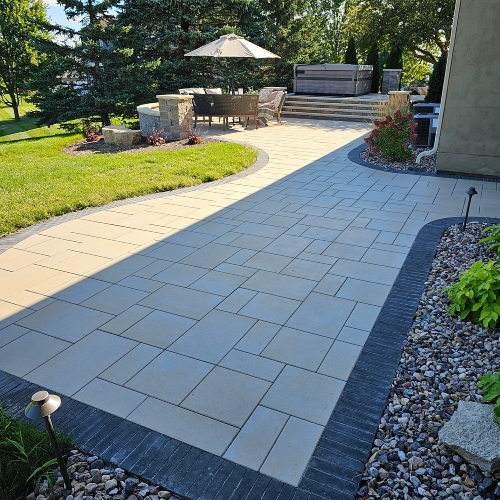 Long paver walkway connecting different patio levels, surrounded by landscaping, built by Carrington Lawn & Landscape in Wisconsin