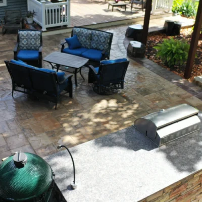 Overhead view of outdoor kitchen, patio seating, and green ceramic grill for expert outdoor kitchen planning by Carrington Lawn & Landscape in Madison