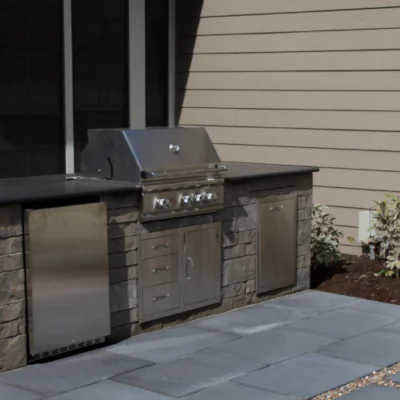 Modern outdoor kitchen with stainless appliances and stone counters for innovative outdoor kitchen planning by Carrington Lawn & Landscape in Madison