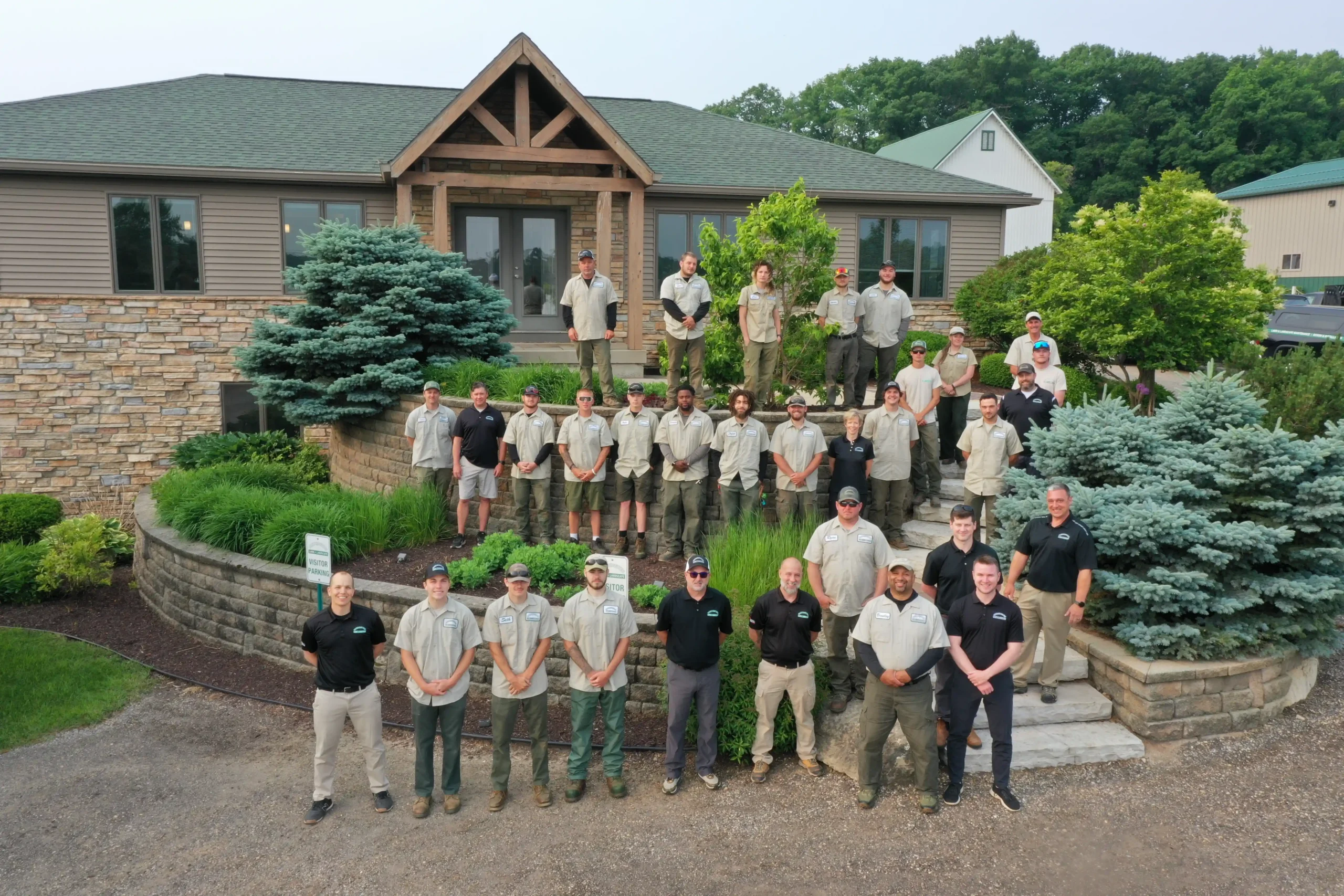 Carrington Lawn & Landscape employees gathered outside their Madison headquarters for a team photo, showing the full staff in front of the office and landscaped entry