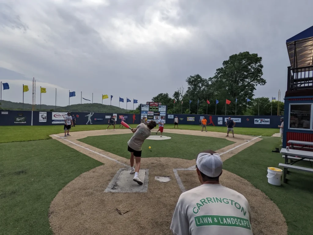 Carrington Lawn & Landscape staff enjoying a company baseball game together on a field in Madison