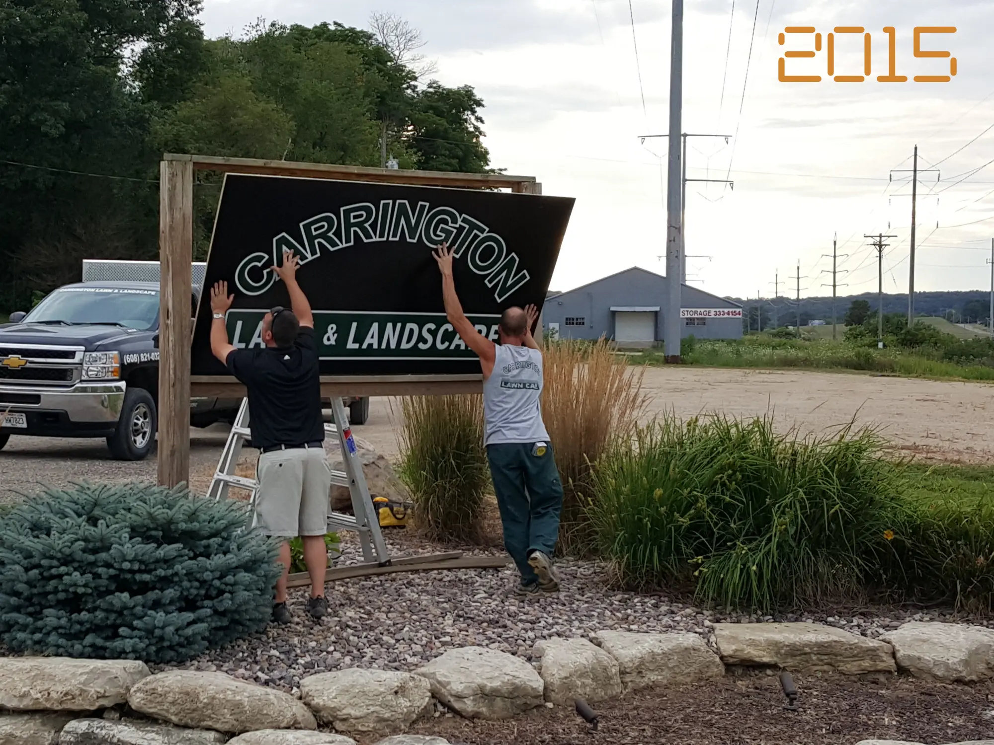 Carrington Lawn & Landscape team members installing the main signage at their Madison location in 2015