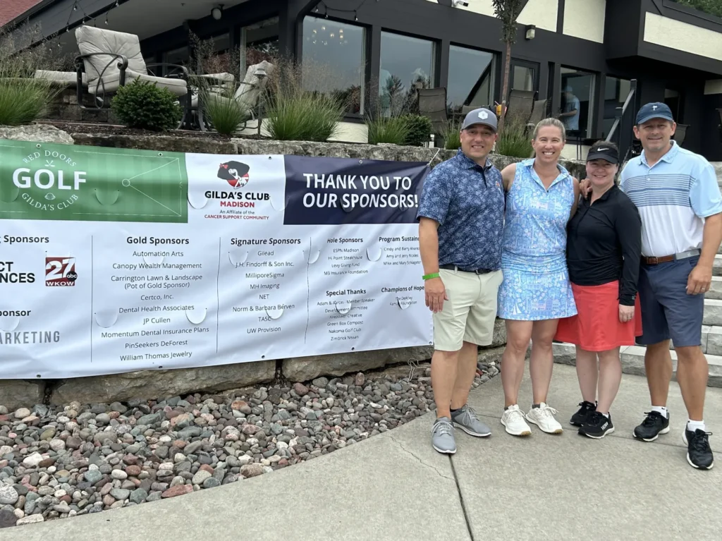 Four Carrington Lawn & Landscape team members standing beside a sponsor banner at the Gilda’s Club Madison charity golf outing