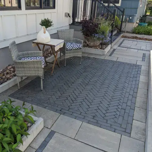Modern patio seating area with stone pavers and greenery designed by Carrington Lawn & Landscape in Middleton, WI — outdoor living space.