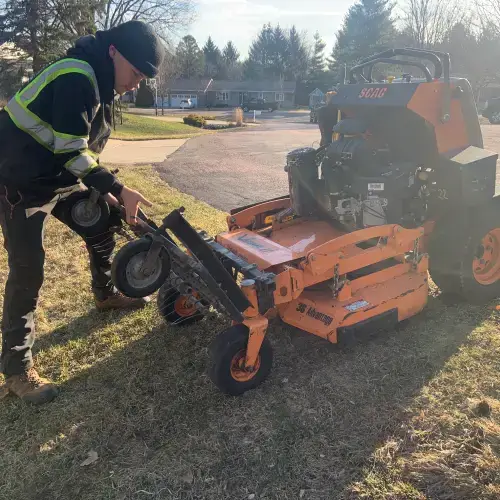 Lawn care basics in Middleton, WI – Carrington Lawn & Landscape team member performing maintenance on a commercial mower