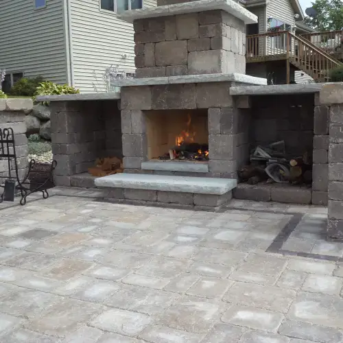 Contemporary stone fire pit and outdoor fireplace showcasing the latest fire pit landscape design trends in Middleton, WI.