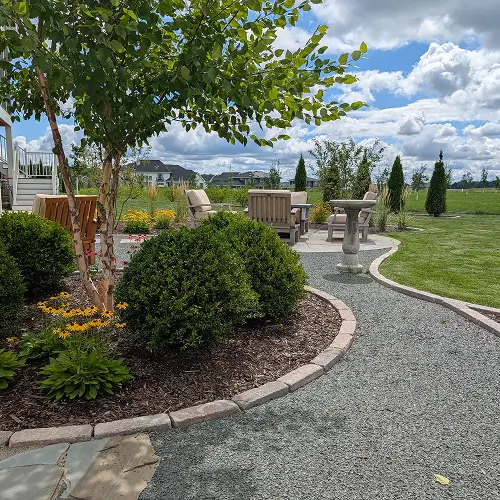 Garden pathway with native plants in climate-adapted landscaping by Carrington Lawn & Landscape in WI