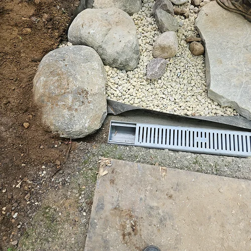 Close-up of dry creek bed drainage system in Madison WI by Carrington Lawn & Landscape, showing stones and water channel detail