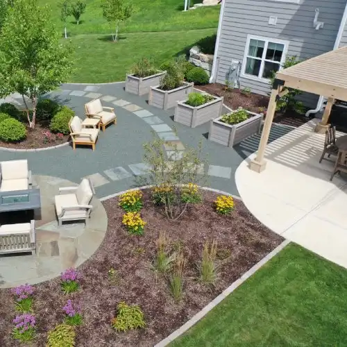 Bluestone patio landscape design with pergola and seating area by Carrington Lawn in Middleton WI