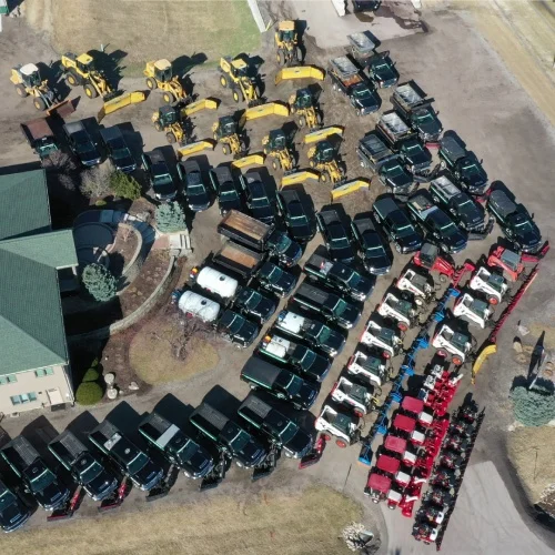 Aerial view of plow trucks, loaders, and salters staged for commercial storms, certified snow professional team by Carrington Lawn & Landscape