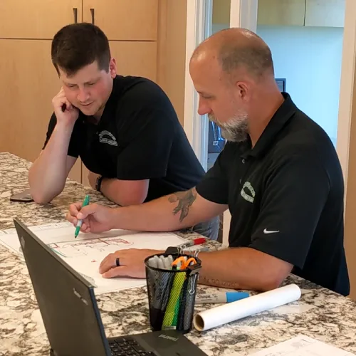 Landscape designer presenting a detailed concept drawing to homeowners during the concept review meeting by Carrington Lawn & Landscape in WI