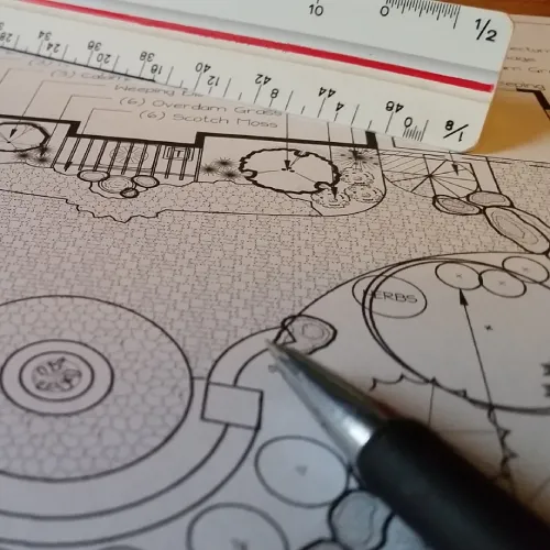 Homeowner reviewing and signing design-build agreement documents with a landscape designer by Carrington Lawn & Landscape in WI