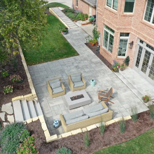 Beautifully designed backyard with patio seating and lush garden illustrating outdoor space design by Carrington Lawn & Landscape in WI