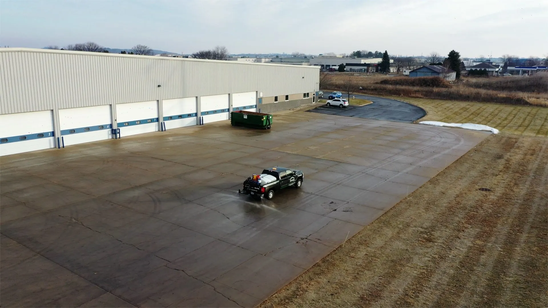 Carrington Lawn & Landscape snow and ice management truck on an empty commercial parking lot, clearing ice in Madison, WI