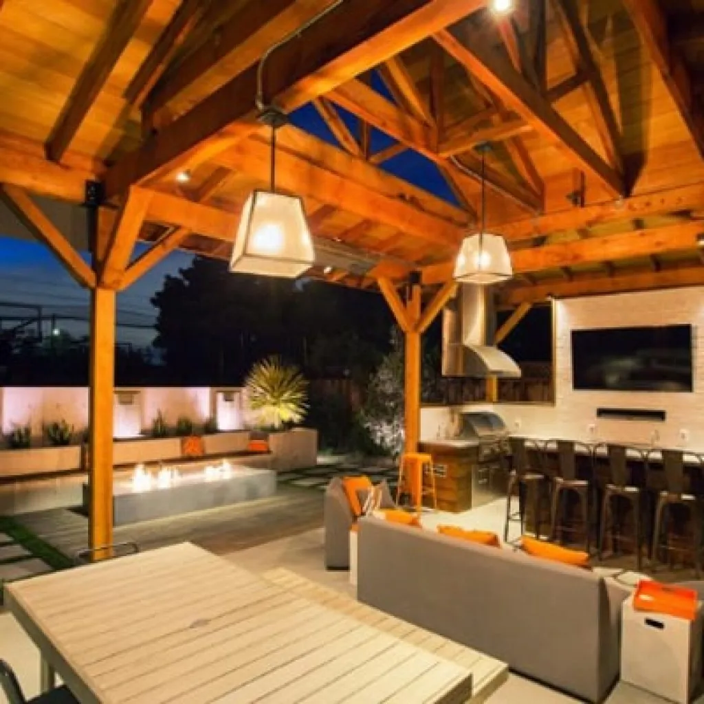 A spacious covered patio with a vaulted ceiling with a landscape lighting design in Middleton, WI