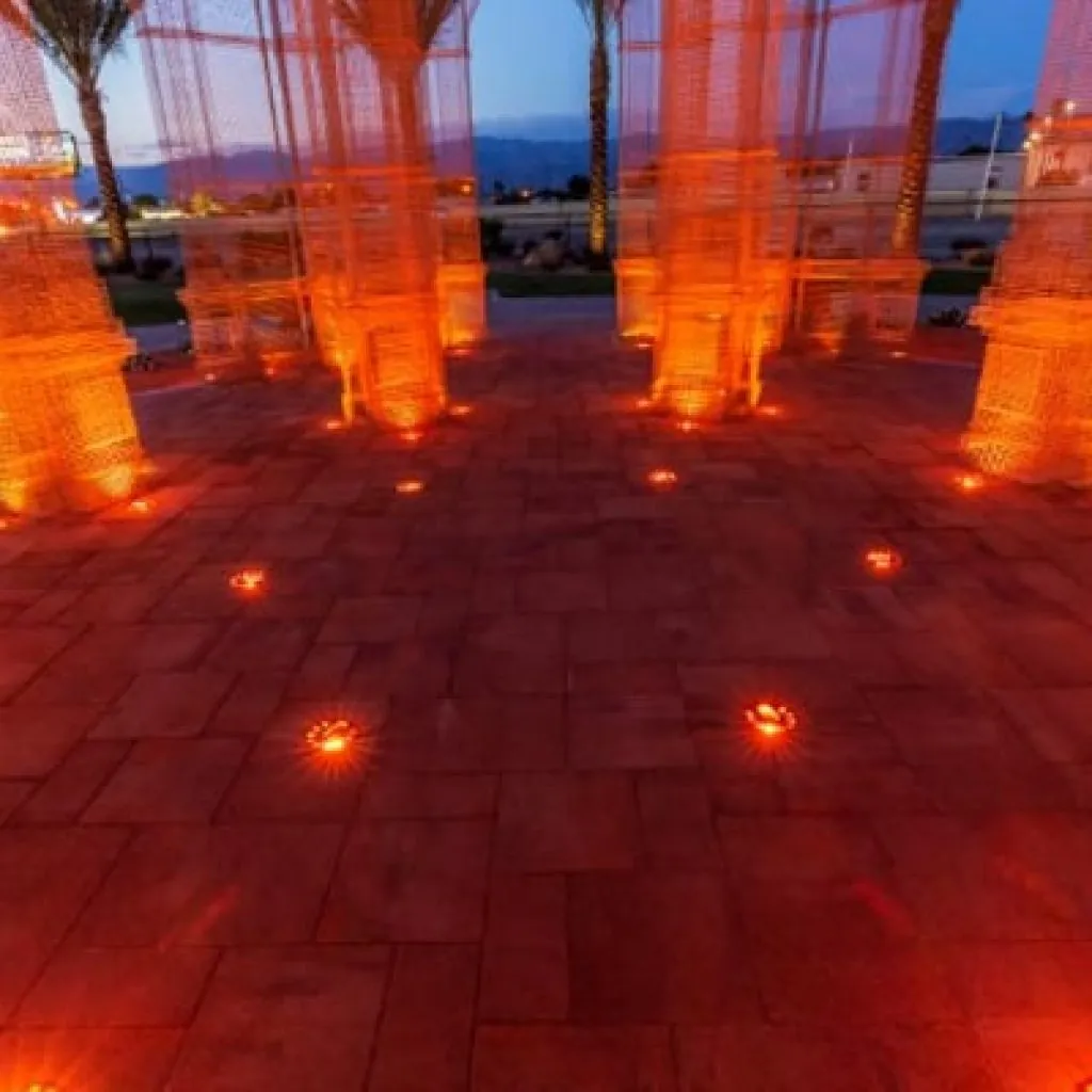 A patio with pavers illuminated by red ground light landcape lightin design in Middleton, WI