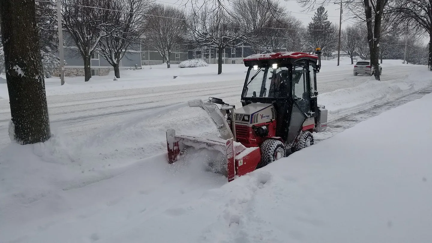 Snow removal machine clearing a brick pathway in winter for snow and ice management in Madison, WI