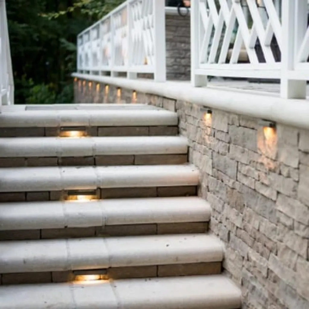 Stone staircase with built-in lighting illuminating each step and the surrounding stone wall