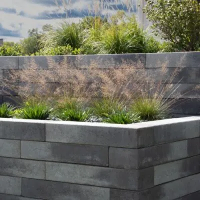 Gray concrete block retaining wall with tiered landscaping instaled by Carrington Lawn & Landscape hardscape design contractors in Middleton, WI
