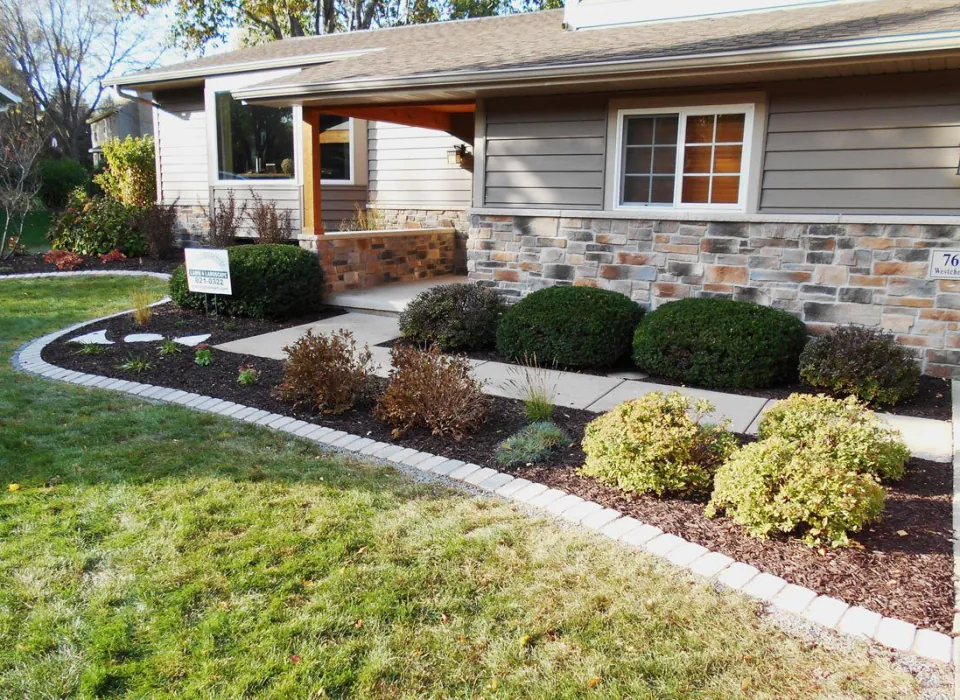 a house with stone and siding, and newly landscaped front yard landscape design build by Carrington Lawn & Landscape in Middleton, WI,