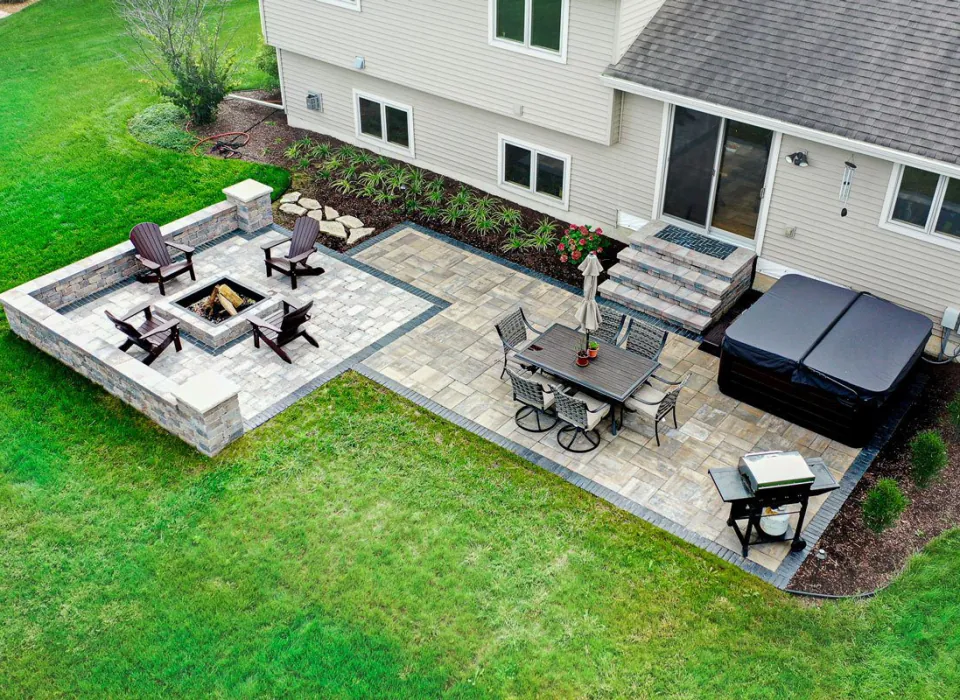 Landscape design build by Carrington Lawn & Landscape in Middleton, WI, featuring a patio with fire pit, dining area, and hot tub.