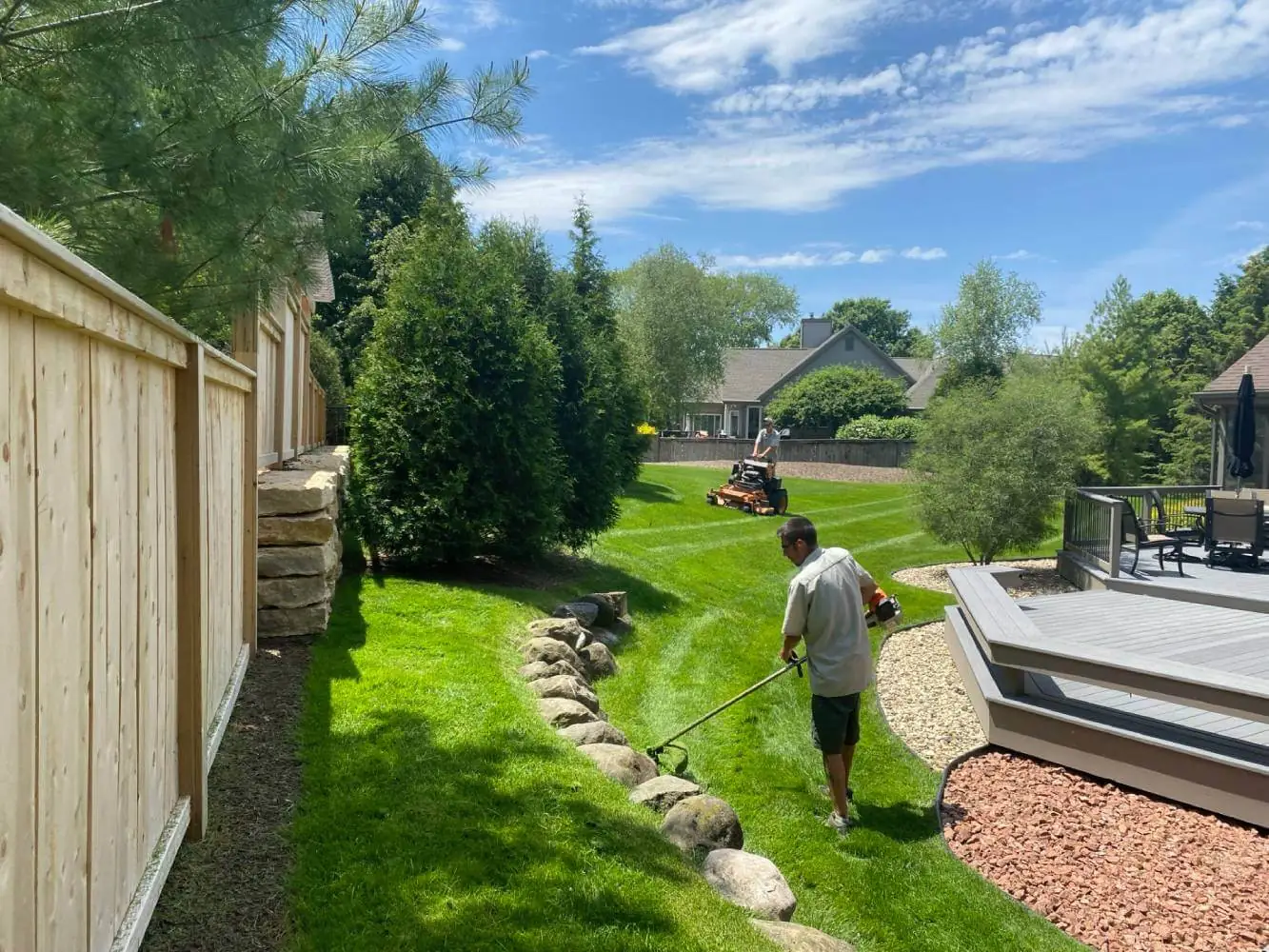 A garden with curved black Euroline aluminum edging separating a lush green lawn in middleton, WI