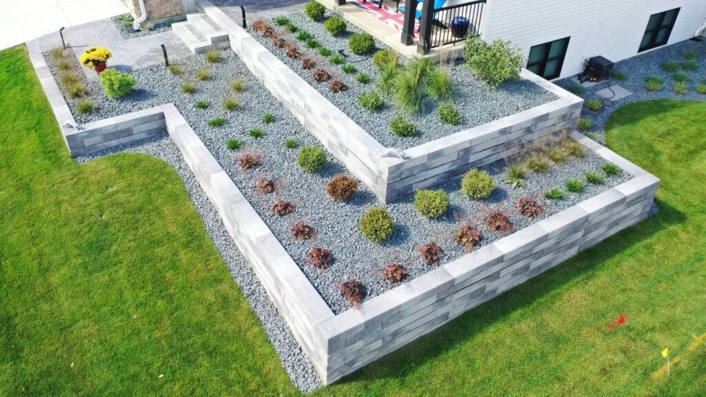 Overhead shot of a tiered raised hardscape garden bed with gray stone walls and gravel in Middleton, WI