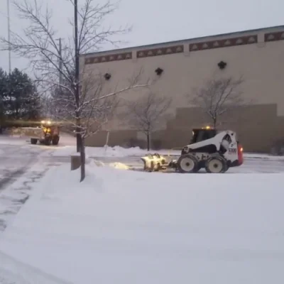 Snow removal machine clearing a brick pathway in winter for snow and ice management in Madison, WI
