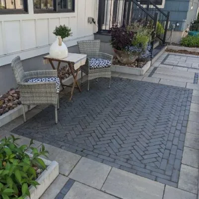 dark grey woven Paver Pattern acting as an accent rug design with larger gray paver tiles surrounding the border 