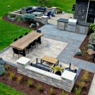 arial image of outdoor modern hardscape installation with multiple seating areas and different pattern and colors of pavers to break up each area 