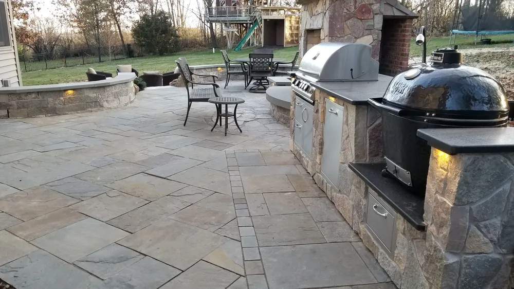 Luxury outdoor kitchen with custom stonework and lush landscaping