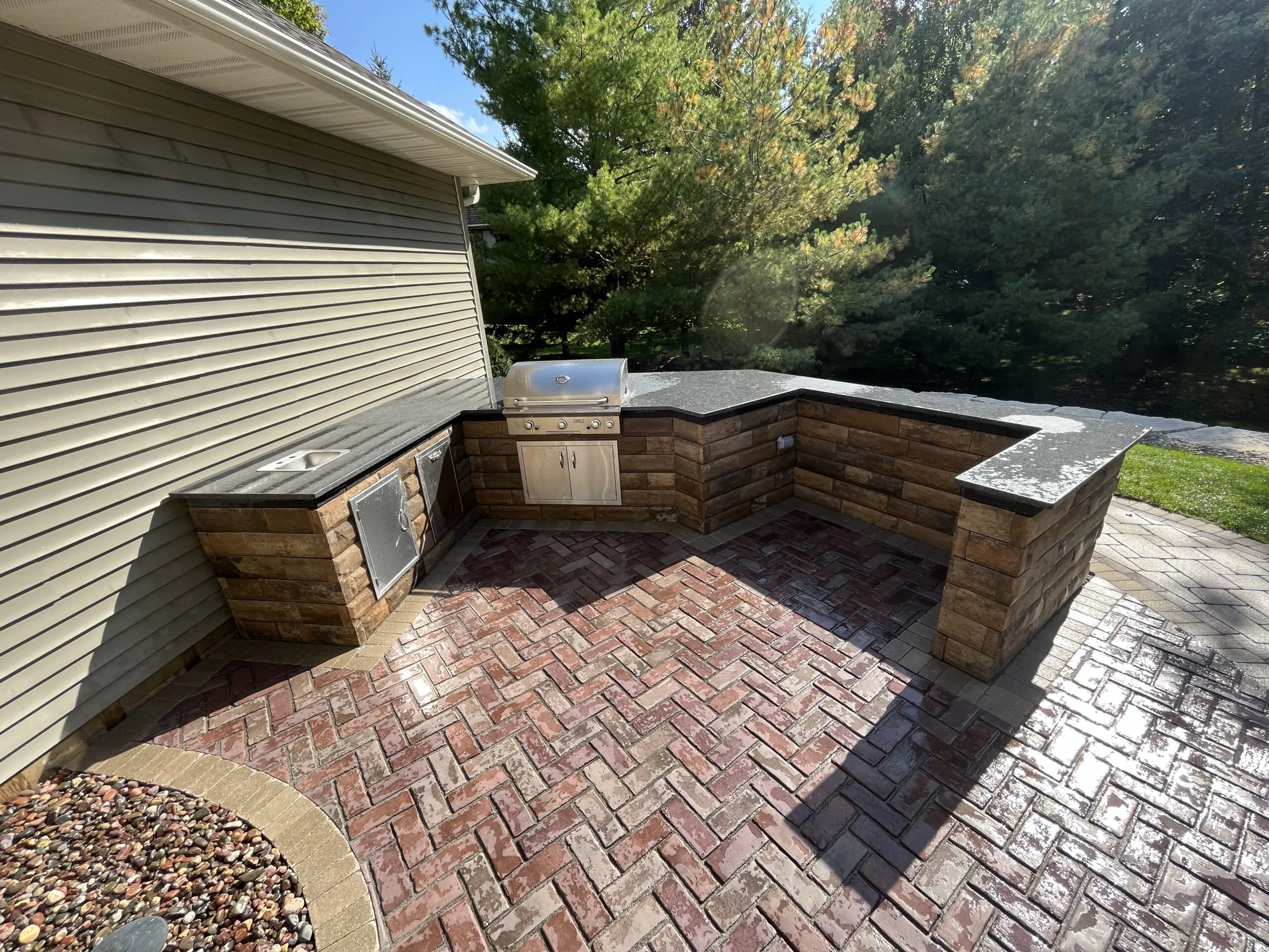 A compact outdoor kitchen with a built-in grill and stone counters, supporting outdoor kitchen middleton wi in Middleton by Carrington Lawn & Landscape.