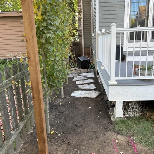 Stepping stone pathway beside deck featuring organic yard design and Madison landscape design by Carrington Lawn & Landscape in Madison