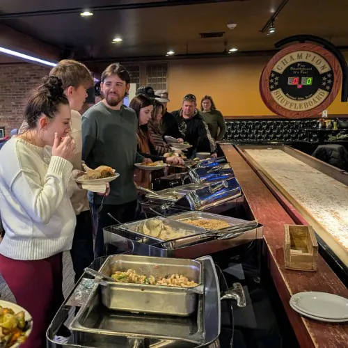 Carrington Lawn & Landscape team lined up at the buffet during the 2025 holiday party in Madison