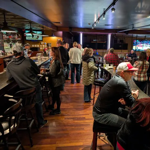 Carrington Lawn & Landscape staff socializing by the bar during the holiday party in Madison